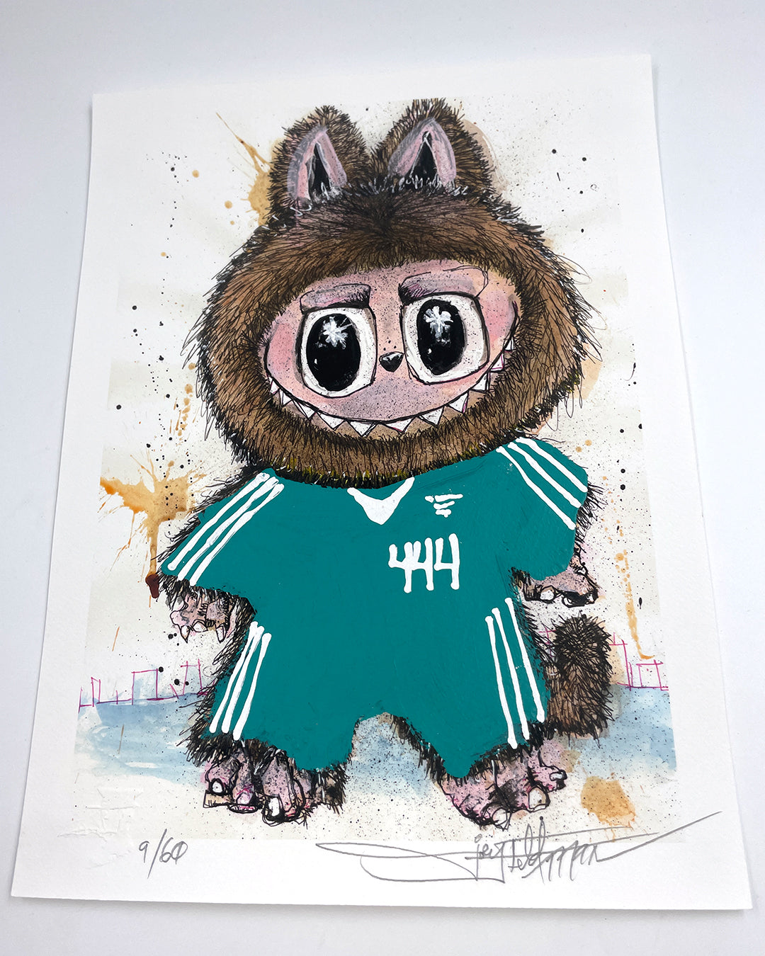 A whimsical creature with big eyes, wide grin, and furry brown ears in a teal 444 jersey stands on paint-splattered paper in this signed, numbered Joey Feldman archival pigment print.