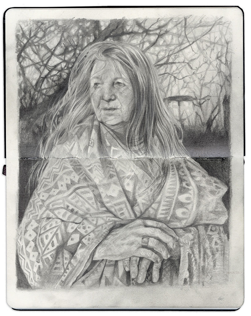 illustration in an open face Moleskine notebook of an older woman in a patterned blanket with long hair standing in front of a tree by artist Roos van der Vliet