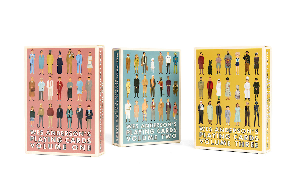 Three boxes of “Max Dalton’s Playing Cards—Wes Anderson Series” (volumes one, two, and three) each showcase Max Dalton’s illustrated characters dressed in iconic outfits from Wes Anderson films, set against uniquely colored backgrounds. These custom-designed playing cards capture the quirky charm and unmistakable style that define Wes Anderson’s cinematic world.