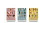 Three boxed sets of Max Dalton Wes Anderson playing cards—Volumes One, Two, and Three—each custom designed with illustrated characters on distinctive pink, blue, and yellow backgrounds that capture the unique charm of Wes Anderson’s world.
