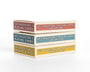 Three boxes labeled Max Dalton Wes Anderson playing cards, volumes one, two, and three, stacked on a white surface. Featuring artwork by Max Dalton, these custom-designed playing cards come in vibrant red, blue, and yellow boxes.