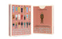 Two boxes of Max Dalton’s Playing Cards Volume One are shown. Beautifully custom-designed playing cards by Max Dalton, the boxes feature illustrated characters from Wes Anderson films on a pink background, with text on the front and back.