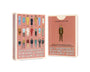 Two boxes of Max Dalton’s Playing Cards Volume One are shown. Beautifully custom-designed playing cards by Max Dalton, the boxes feature illustrated characters from Wes Anderson films on a pink background, with text on the front and back.