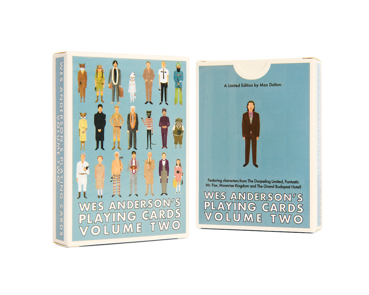 Two boxes of Max Dalton’s Playing Cards Volume Two are shown. Custom designed by Max Dalton, the front features illustrated characters from Wes Anderson's films on a blue background, while the back displays a single character in a suit. Both boxes prominently show the product title, making these Max Dalton playing cards a must-have for collectors and fans alike.