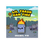 A cute 100% Soft soft enamel pin featuring a smiling trash can with flames, displayed on a backing card that reads “Lil Trash Can Fire” and shows cartoon trash cans, garbage, and a city skyline in the background.