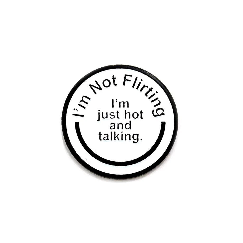 A round lapel pin by Spoke Art featuring the text Im Not Flirting. Im just hot and talking. in black letters on a white background.