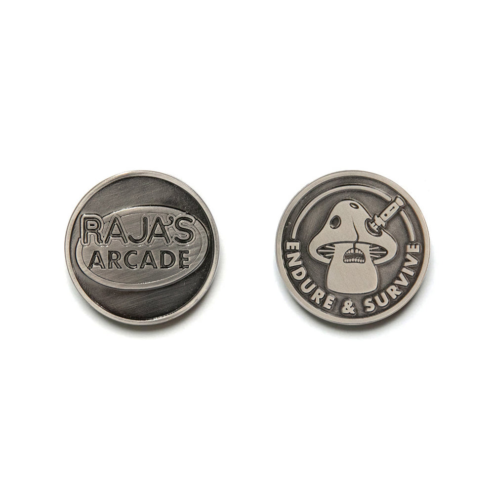 Two round metal tokens: one side reads RAJAS ARCADE; the other, designed by Bruce Yan, shows a stylized joystick and controller with ENDURE & SURVIVE inscribed around the edge.