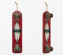 A GATS vintage skateboard art piece, mounted vertically on the wall, features a red deck with a striking black and white eye design in a diamond shape. It includes metal parts at the top and bottom and a rope loop for hanging, making it an intriguing addition to any San Francisco art market.