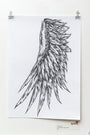 Rhys Coopers ink on paper artwork, Angel Wing, features a black and white preliminary sketch of a detailed feathered wing with intricate patterns and long, flowing lines, clipped to a white wall.