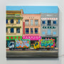 Jessica Hesss vibrant oil on panel depicts a lively Chinatown Delivery scene, featuring colorful trucks adorned with graffiti and parked in front of three distinctively signed buildings, capturing the energetic spirit of an urban street.