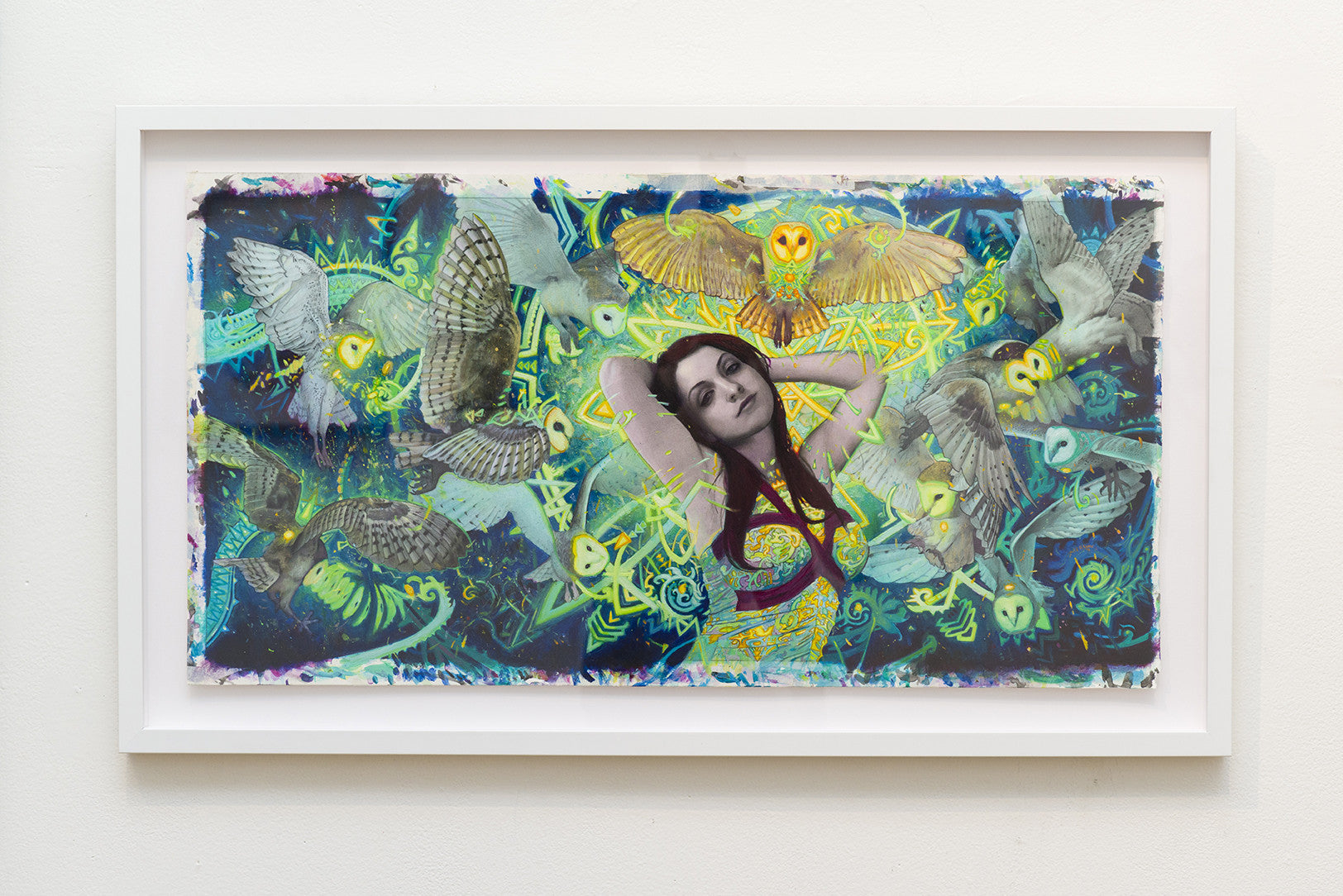 A framed artwork by Rod Luff in pencil showcases a woman at the center, surrounded by phantom-like owls. These are set against a colorful abstract background with swirling patterns and vibrant shades of blue, green, and yellow.