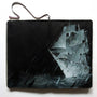 A sketchbook reveals Kim Cogan’s dramatic acrylic painting of a ship in a dark stormy sea. Bold brushstrokes in black, white, and gray shades convey intense movement and drama.