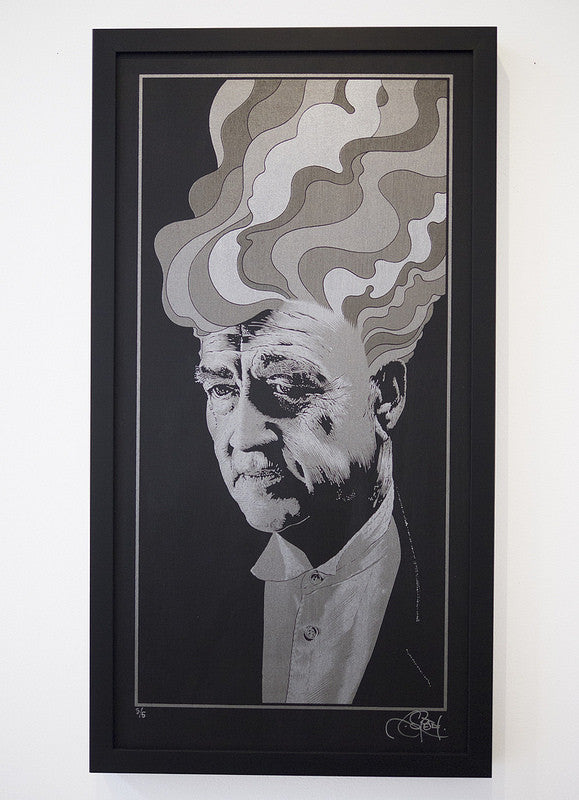 A framed Chuck Sperry artwork features a portrait with stylized, swirling smoke shapes from the persons head. The monochromatic palette of gray, black, and white evokes David Lynchs cinematic style, amplifying its dramatic effect.