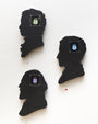 Three silhouetted profiles hang on a light wall, crafted from hand-cut wood with small digital LED displays showing lock icons in green, blue, and purple. These portraits reflect the meticulous artistry of an acrylic painting in Matt Ritchies distinctive style.