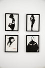 Four minimalist, framed artworks by Conrad Roset adorn a white wall. Crafted with India ink, each piece showcases a black-and-white stylized figure with subtle color highlights, posed in contemplative or serene stances.
