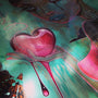 Acrylic on wood panel, Stitched Up by Caia Koopman features a stylized crying woman holding a stitched red heart against teal and black splatters.