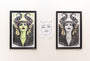 On the wall hang three artworks: two vibrant, stylized portraits of a dark-haired woman in Rhys Coopers screen print style on the left and right, and a minimal black-and-white face sketch in the center.