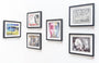 Nimit Malavias artworks adorn a white wall, featuring both abstract and realistic styles: a colorful portrait, nature line drawings, a detailed face with multicolors, a car, an abstract pattern, and a woman in profile. Each piece is uniquely styled and engaging like entries in a Moleskine exhibit.