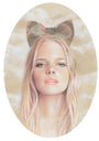 Bec Winnels framed artwork portrays Genevieve with long blonde hair and a large decorative bow. Her serene expression matches the soft, cloud-like background, elegantly enclosed in an oval shape.