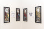 Framed comic-style portraits by Rhys Cooper, featuring varied expressions and color schemes reminiscent of Red Hood, adorn a white wall. Screen print editions include an edition of 125 with sketches like faces and abstract designs interspersed.