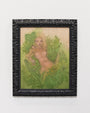 Audrey Kawasakis artwork showcases a nude woman with long hair amidst lush foliage on a wooden panel, surrounded by an intricate black frame. This piece embodies the essence of Suggestivism: Resonance against a plain white wall.