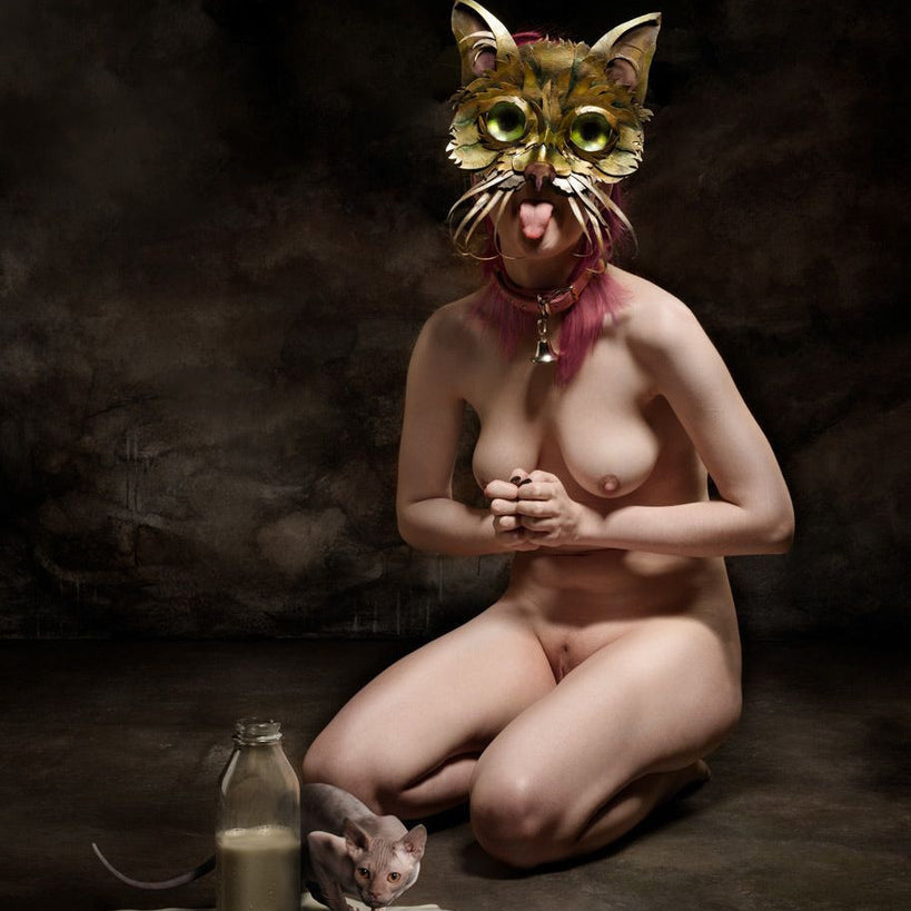 A person in a cat mask kneels with clasped hands against a dark backdrop. A milk bottle and two hairless cats, one drinking spilled milk, enhance this surreal scene—ideal for Limited Edition Posters or Digital Archival Prints by Ransom & Mitchell for art lovers.
