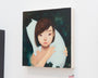 At the Supersonic Invitational group show, a UYU painting features a short-haired person embracing an abstract cat figure against a dark, starry sky. The artworks iridescent oil and sculpted elements beautifully shine on the white gallery wall.