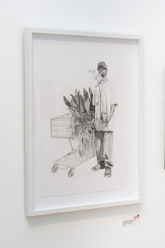 Joel Daniel Phillips charcoal and graphite artwork shows a bearded man smoking next to a shopping cart full of leaves. This black-and-white piece, part of the Supersonic Invitational group show, decorates a white gallery wall.