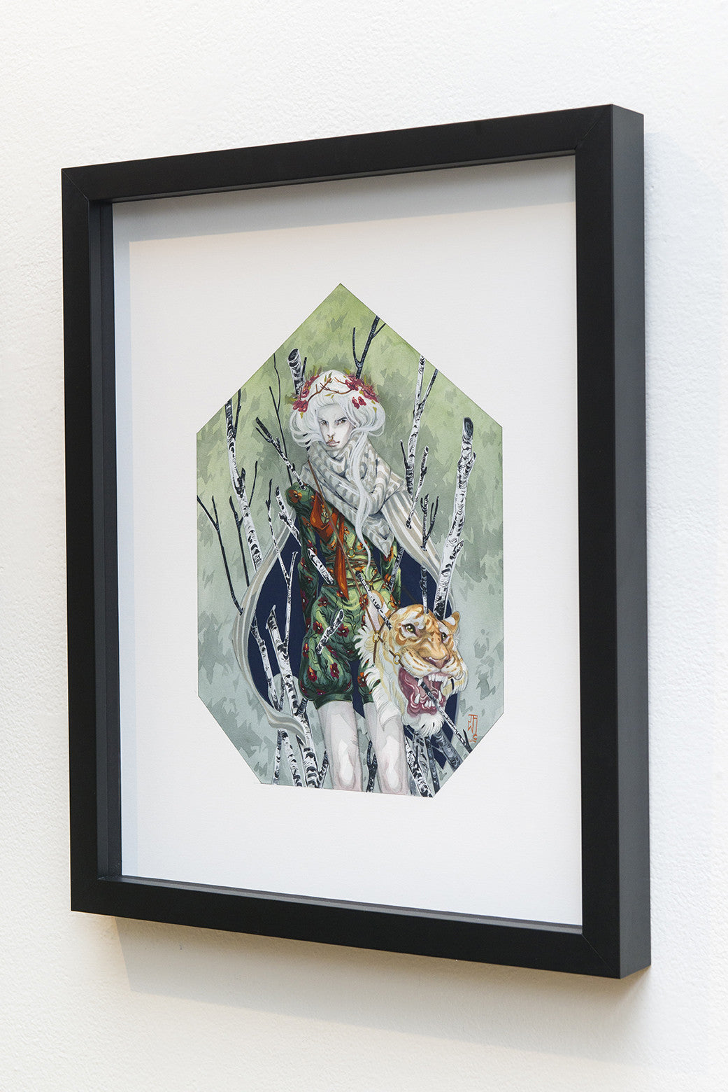 A framed piece by J.A.W. Cooper depicts an elf-like figure with long white hair in ornate attire beside a tiger. Crafted with India ink and gouache, the scene includes white birch trees and lush green foliage, all within a hexagonal frame.
