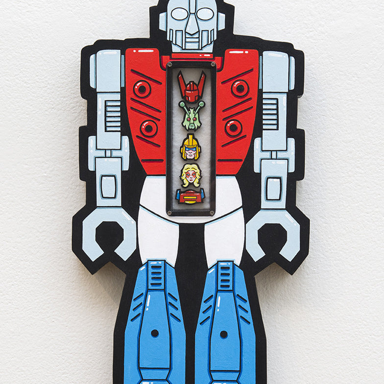 This vibrant hand-cut wood artwork by Matt Ritchie showcases a robot with bold red, blue, and white tones. A transparent center reveals three smaller stacked robot heads, elegantly mounted on a pristine white wall.