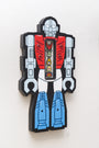 This acrylic art piece by Matt Ritchie features a stylized robot with a red chest, blue legs, and a grey head. The open chest reveals smaller figures inside. Displayed on a white wall, it highlights intricate details and vibrant colors.