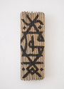 A GATS rectangular wood art piece, showcasing a carved abstract geometric pattern with intersecting lines in dark ink. Its textured surface mimics burnt driftwood and is displayed on a white wall.