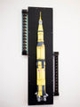 A detailed model of the Saturn V from Steve Yamane, echoing Kubricks visionary style, is mounted vertically on a black panel with electronics on the upper left and lower right. The yellow and gray sections display 237 and USA.