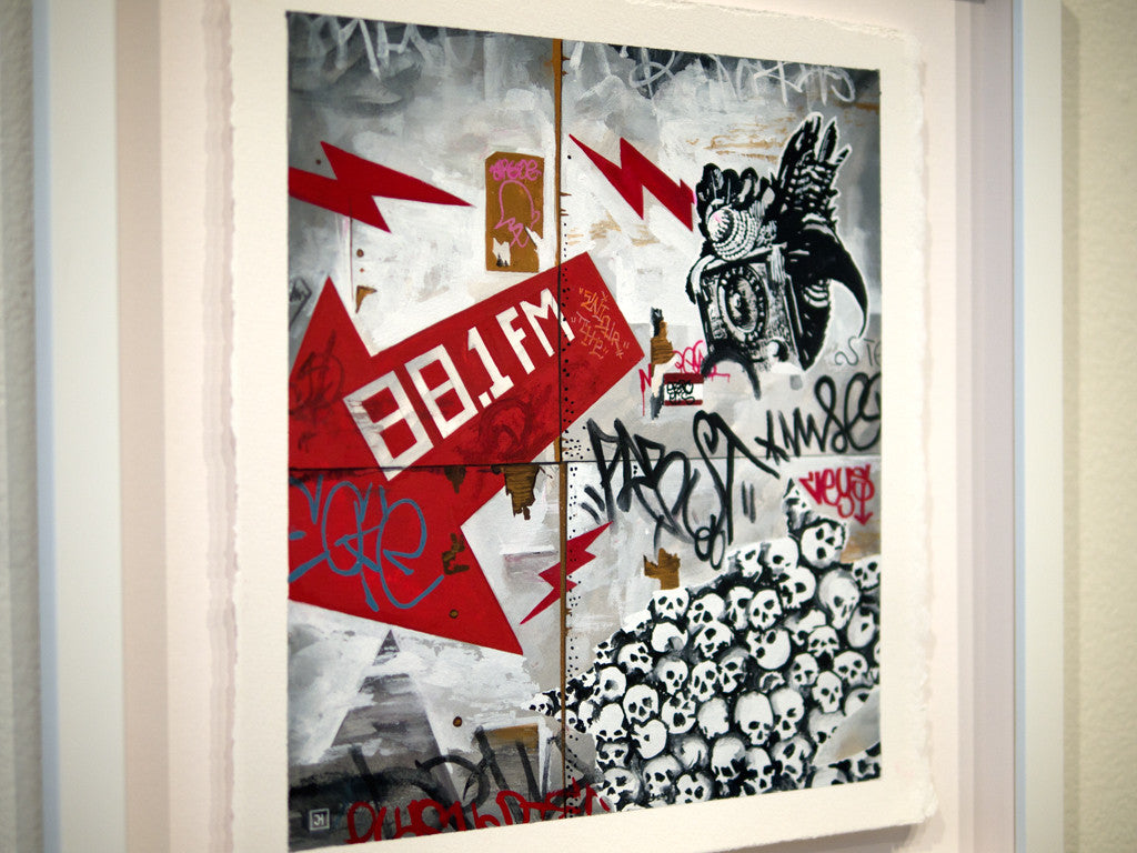 Jessica Hesss custom framed artwork features graffiti-style visuals with red lightning bolts and 88.1 FM amidst skull patterns, abstract shapes, and detailed designs in black, white, and red, echoing her dynamic gouache painting style.