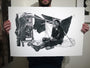 A person holds a Joel Phillips black and white artwork as a fine art giclée print on Italian cold press watercolor paper, showing a seated man amid fabric near a cart and umbrella. This detailed drawing conveys a somber mood.