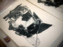 A detailed black and white illustration by Joel Phillips shows a reflective person sitting on the ground surrounded by fabric and poles, with hands resting on their lap. A small box, possibly matches, sits in the corner. This fine art giclée print uses archival Epson HDR inks on large Italian cold press watercolor paper.