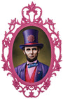 A portrait by Scott Scheidly features a man in a vintage ornate pink frame at Spoke Art Gallery. He wears a purple top hat with a flower, whimsical purple coat, red waistcoat, and blue bow tie, set against a muted green background that merges history and fantasy.