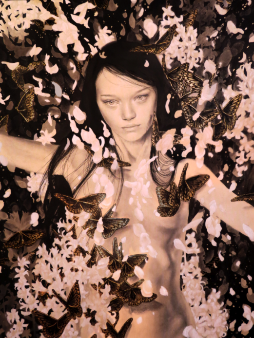 A woman with long hair is enveloped by swirling brown and white petals and butterflies, highlighted with gold leaf. The monochrome swirl background contrasts, capturing the ethereal elegance of Alessandra Marias watercolor style.
