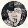 Framed artwork by Alex R. Kirzhner: On printmaking paper, a split-face image shows the left half with a mischievous expression under a black hat, and the right half with a wide-open mouth and wired eye, symbolizing transformation or duality.