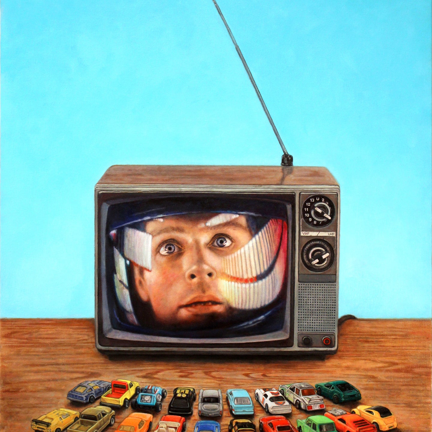 A vintage TV, echoing Allan Innmans style, shows a mans surprised face. In front, small toy cars are neatly placed on wood, capturing an art sale vibe against a solid light blue backdrop.
