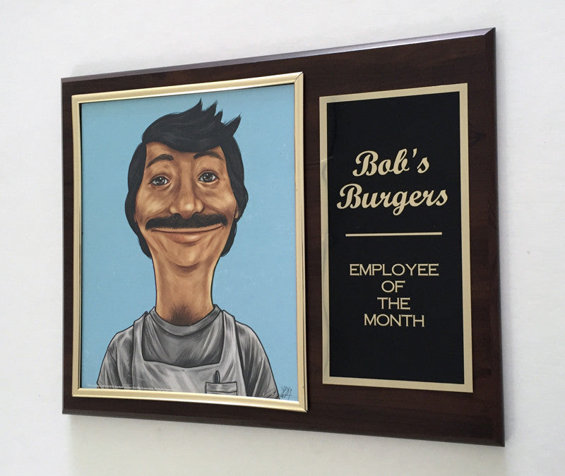 This Cuyler Smith archival digital print plaque showcases a cartoon character with dark hair and a mustache, inscribed Bobs Burgers Employee of the Month in gold on black. It features a wooden frame and was spotlighted at the Bobs Burgers art show at Spoke Art NYC.
