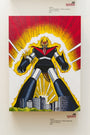A towering Joemur robot poster, reminiscent of Manzinga, stands over a cityscape with an explosive backdrop. It features a red and black torso, yellow and black limbs, and a spiky helmet. Pricing details and the gallery name Spoke Art are visible on the wall.