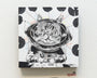 A whimsical Ken Garduno illustration of a cat astronaut at a control panel, inspired by Lil Bub art. The background has colorful dots and radiating lines that add playfulness to the black-and-white design. Offered as limited edition posters.