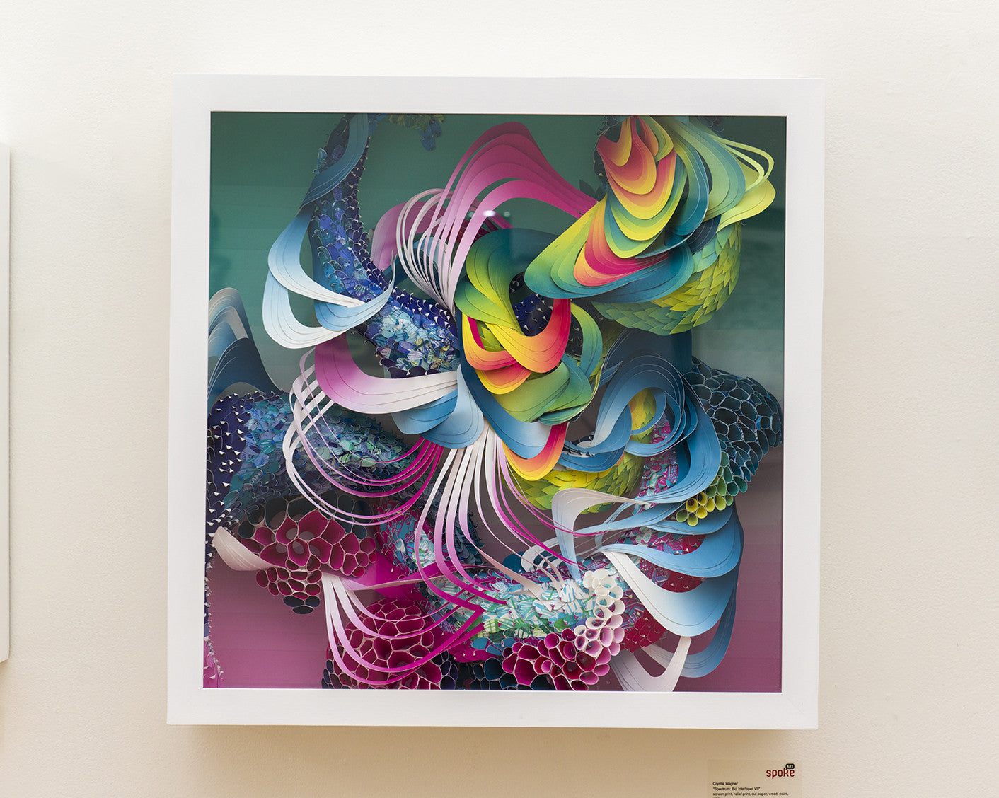 A vibrant abstract artwork with a 3D effect, echoing Crystal Wagners style, features swirling ribbons and geometric shapes in pink, blue, yellow, and green within a square frame.