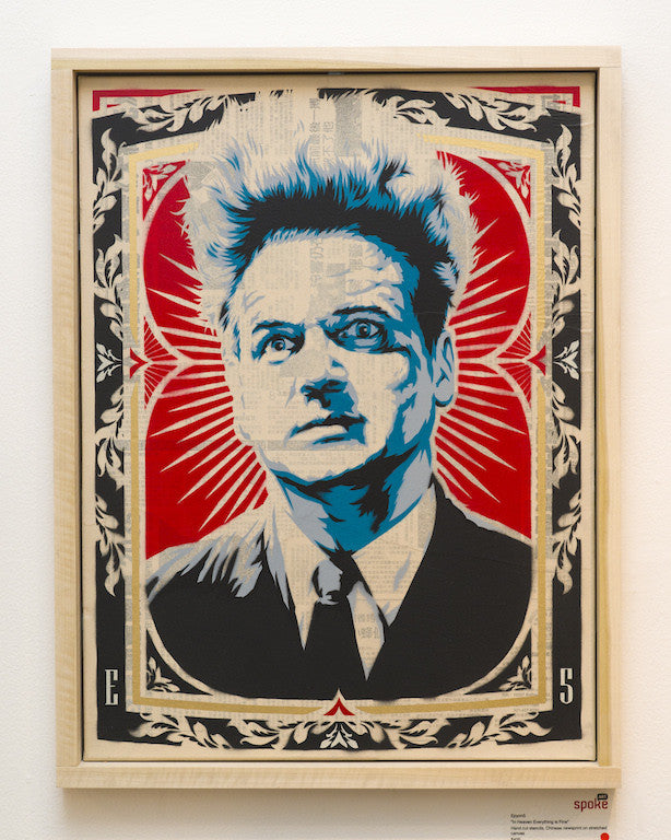 A stylized portrait with spiky hair by Epyon5 features blue tones against a red and black ornate background, made with hand-cut stencils. The intense expression and vintage poster aesthetic seamlessly blend with hints of Chinese newsprint.
