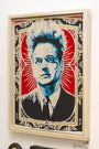 Epyon5 presents a vibrant framed portrait of a spiky-haired man, crafted using hand-cut stencils. The stylized poster image features a blue, white, and red palette. Red rays fill the background, while ornate black and white borders evoke Chinese newsprint.