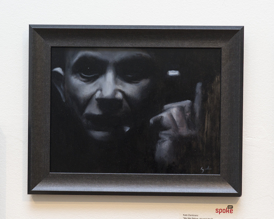 A mysterious and contemplative oil on panel artwork by Kate Zambrano features a person with a somber expression holding a cigarette in a shadowy setting, elegantly framed in black wood. Payment plans are available.