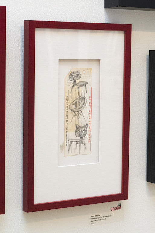 A framed graphite drawing by Jason DAquino features four cats and the text DO NOT WRITE IN THIS SPACE, with 399 on a tag. The red frame includes a white mat and is mounted with a plaque labeled spoke, evoking Detective Williams enigmatic style.