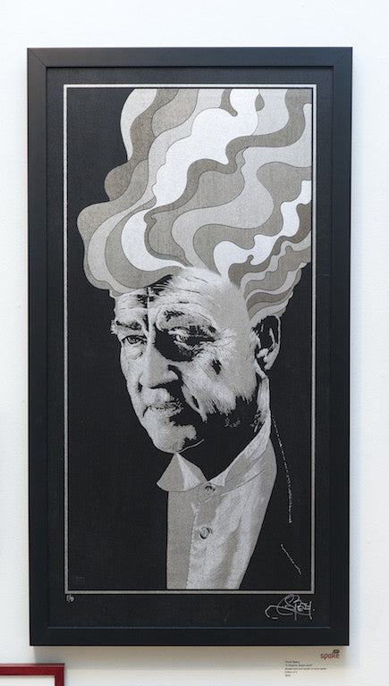 This grayscale framed artwork by Chuck Sperry depicts a suited man with abstract, wavy shapes emanating from his head, evoking a David Lynch scene with its dramatic and intricate screen print techniques.