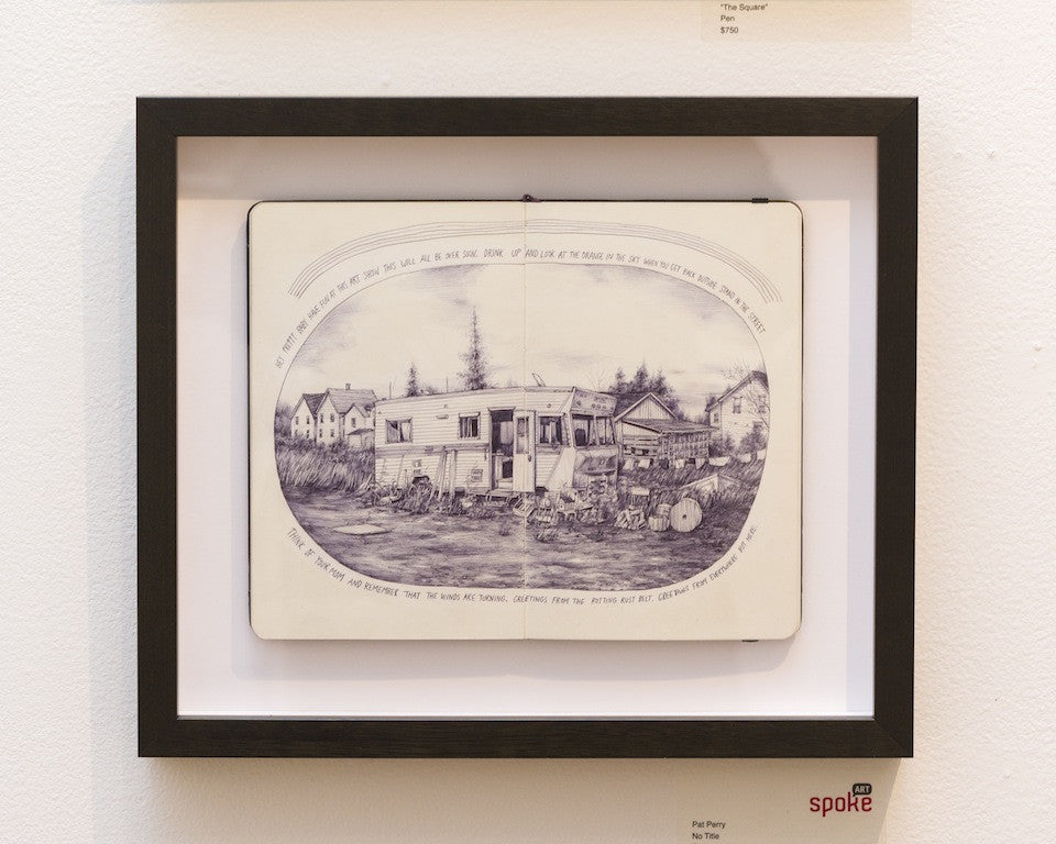 This captivating framed artwork by Pat Perry showcases an open sketchbook featuring a detailed pen drawing of a trailer and surrounding houses, with arching quotes. Displayed prominently on a gallery wall, it makes for an engaging visual centerpiece.
